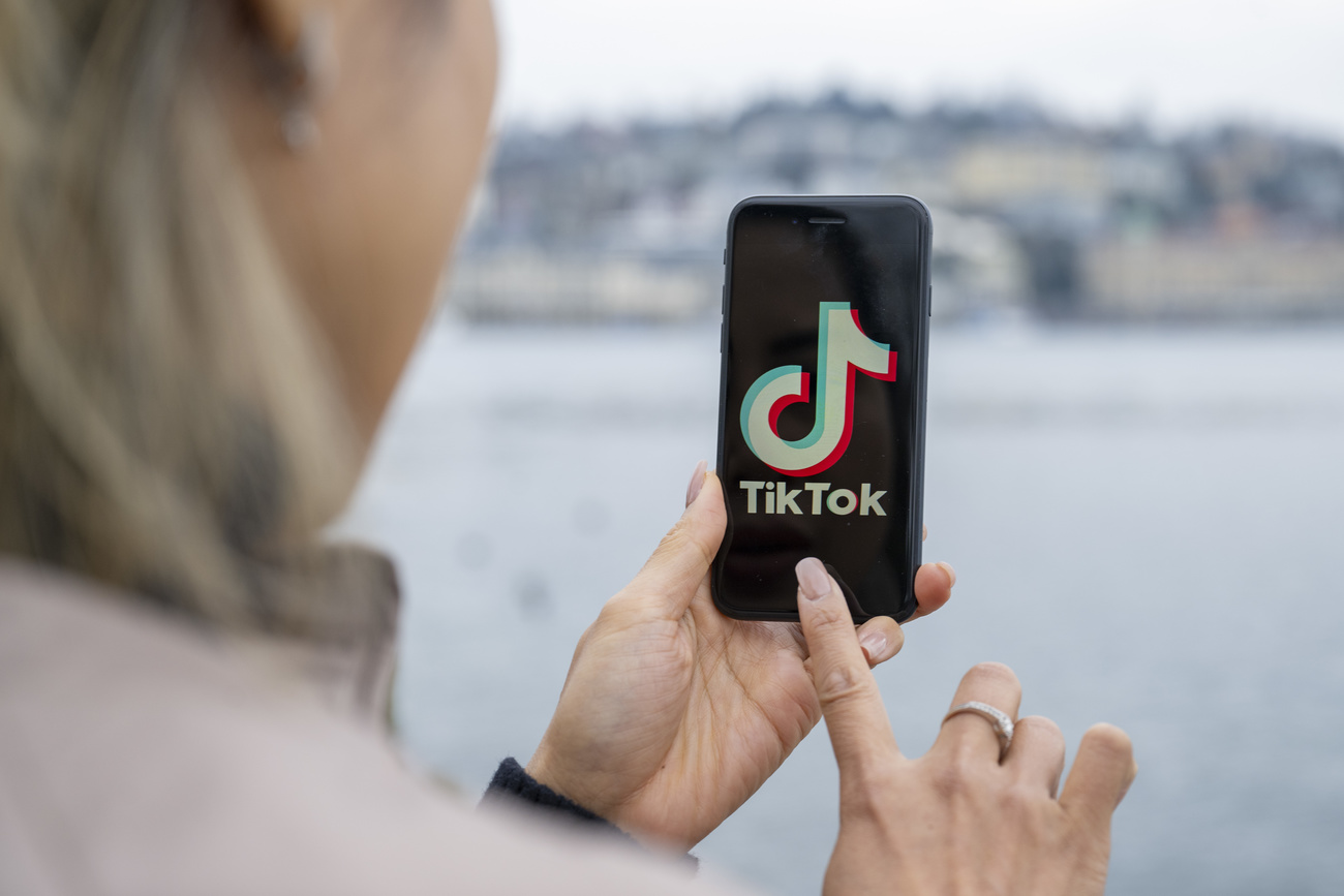 Uma jovem utilizando o celular para ver Ticktok