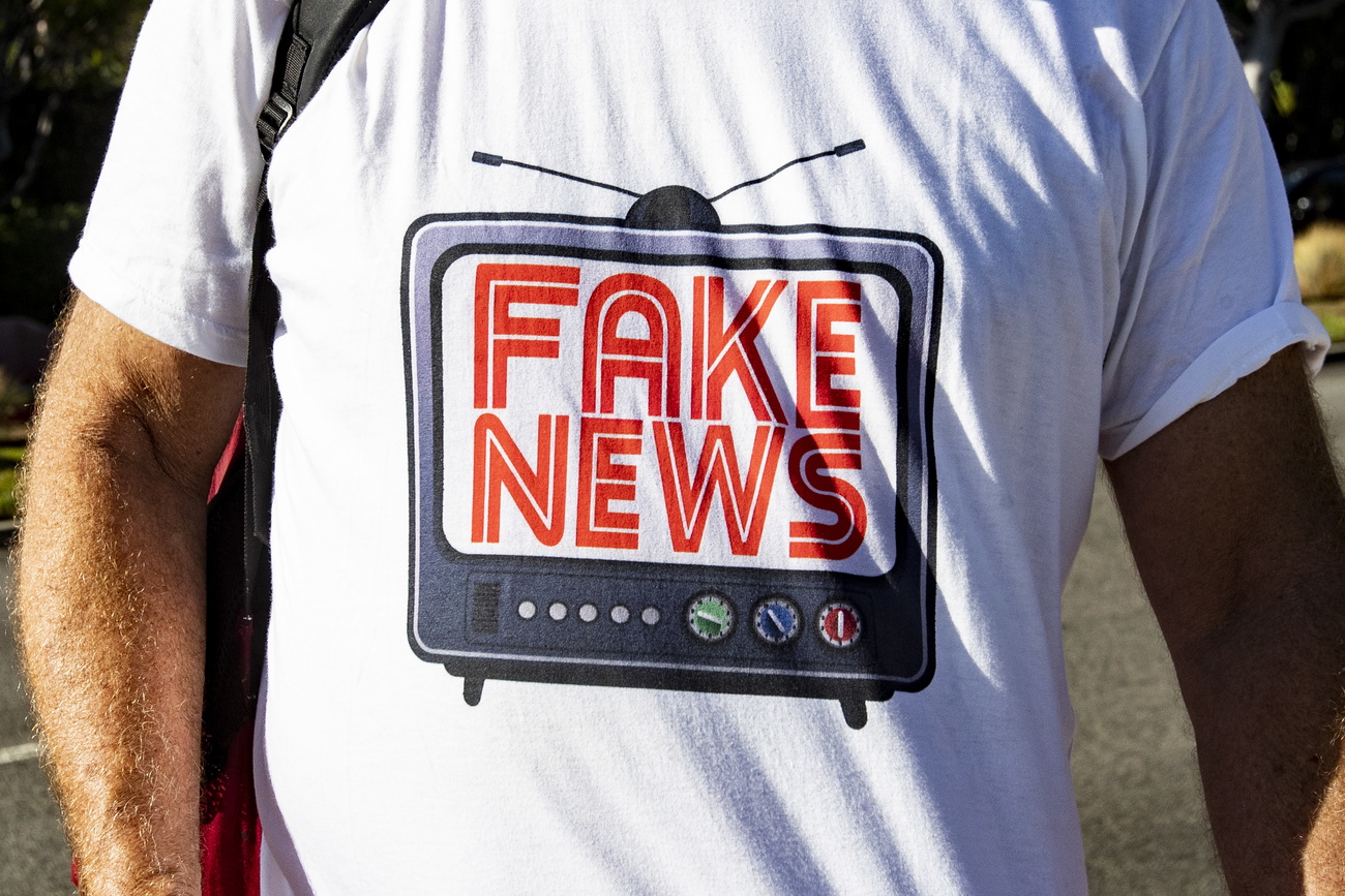 Pessoa trajando camiseta com inscrição "Fake news".